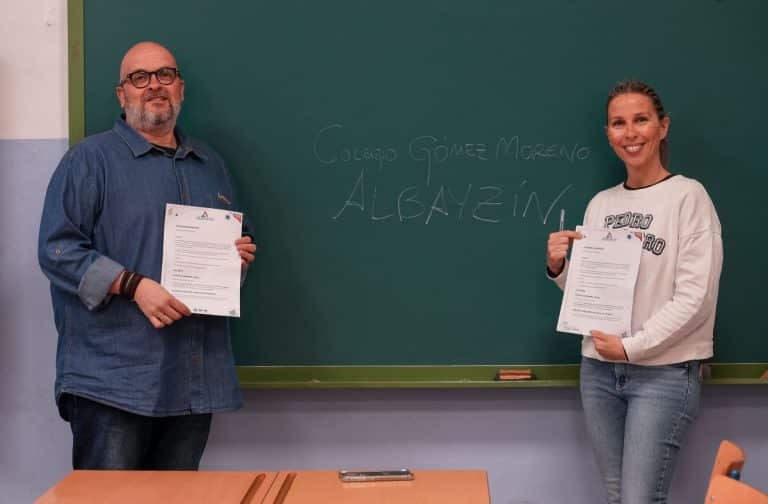 El CEO de APDI Group, Juan Antonio Rosado, y la directora del colegio público Gómez Moreno de Granada, Sara Arteaga, firman la donación de libros a la biblioteca del centro